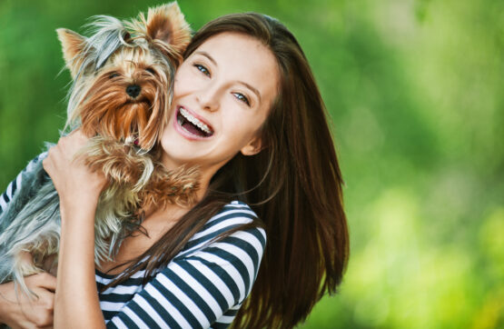 young woman having a good time with her dog, happy with the dog waste removal services in redlands australia